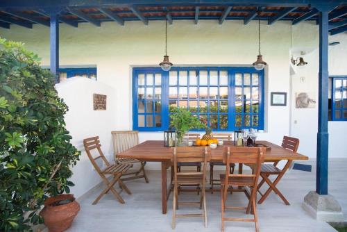 a dining room with a wooden table and chairs at FABULOUS BUNGALOW , WIFI, SWIMMING POOL AND BEACH in Pasito Blanco