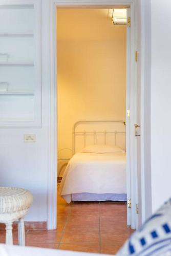 a small bedroom with a bed in a doorway at FABULOUS BUNGALOW , WIFI, SWIMMING POOL AND BEACH in Pasito Blanco