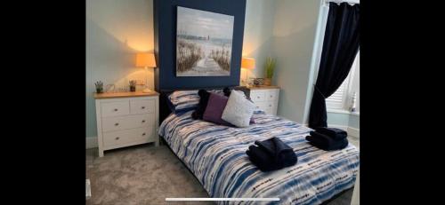 a bedroom with a bed and a picture on the wall at Ground Floor Apartment in Exmouth