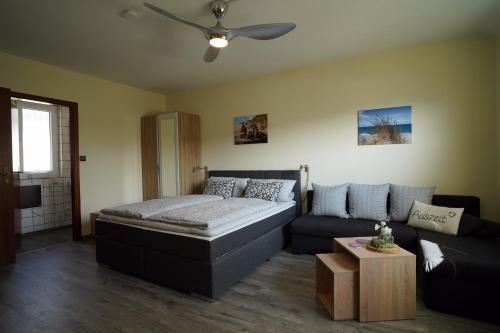a living room with a bed and a couch at Auszeit - Ferienwohnung und Appartements in Bad Sooden-Allendorf