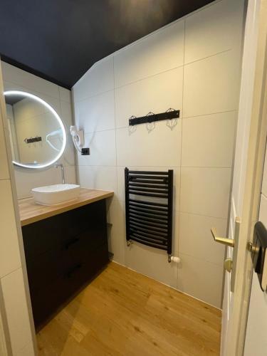 La salle de bains est pourvue d'un lavabo et d'un miroir. dans l'établissement LE PETIT CLAVIER, à Lagord