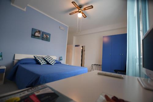 1 dormitorio con 1 cama azul y ventilador de techo en Bed and breakfast Coppadicuocobb, en Mattinata