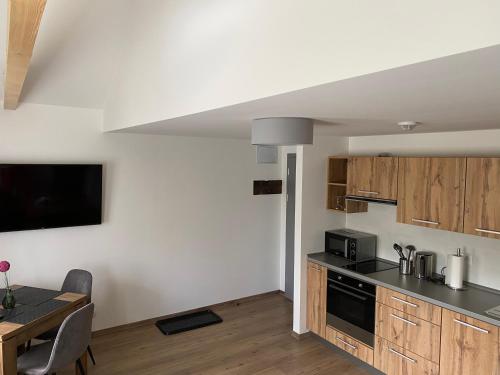 a kitchen with wooden cabinets and a table with a tableablish at Usedlost Pivoňka in Mnichov
