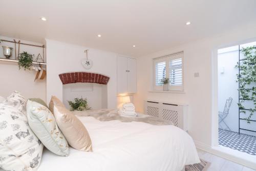 a white bedroom with a large bed and a window at Central Apartment - with Patio and Sofa Bed! in Cheltenham