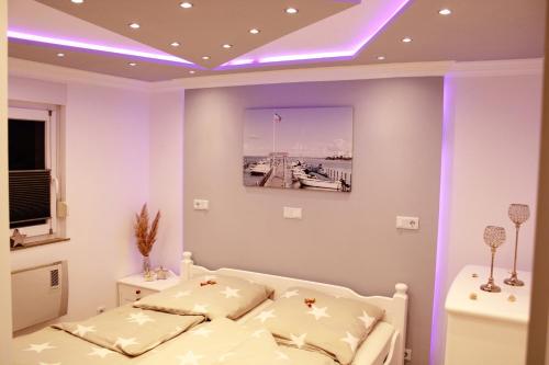 Schlafzimmer mit einem Bett mit lila Beleuchtung in der Unterkunft Schleibungalow Nr15 zw Ostsee und Schlei in Kappeln