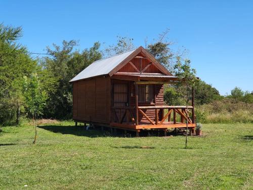 una pequeña cabaña de madera en un campo de hierba en Chacra Mandala en Gualeguay