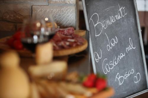a table with pizzas and a chalk board with a sign at La Cascina Nel Bosco in Faicchio