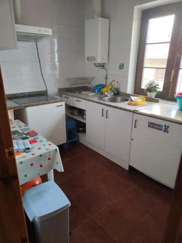 a kitchen with white cabinets and a sink at Albergue La Senda in Rabanal del Camino