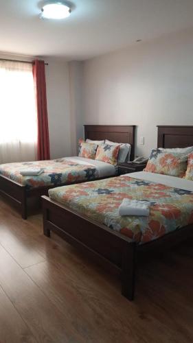 1 dormitorio con 2 camas y ventana en HOTEL CENTRAL en El Tambo