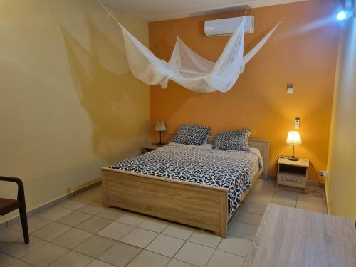 a bedroom with a bed with a mosquito net at Magnifique Villa Riad avec piscine proche plage in Saly Portudal