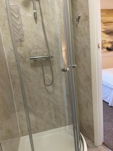 a shower with a glass door in a bathroom at CARIS Guest House in Southend-on-Sea
