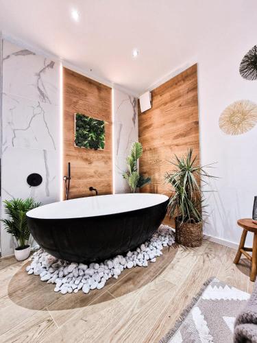 a large bath tub in a bathroom with plants at Holiday Home Sofia La vie est belle in Bollendorf