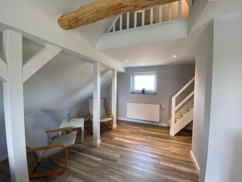 an attic room with a staircase and wooden floors at Design Apartment Sasaki in Celle