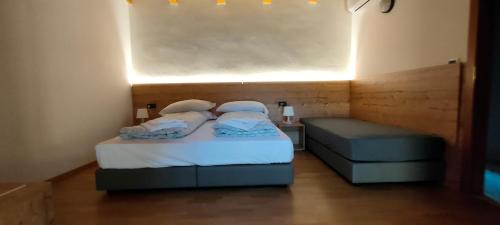 リーヴァ・デル・ガルダにあるCasa Francescaの小さなベッドルーム(ベッド2台、ベンチ付)