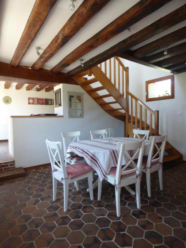 une salle à manger avec une table et des chaises blanches dans l'établissement la pause campagne, à Pullay
