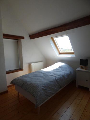a bedroom with a bed in a room with a window at la pause campagne in Pullay