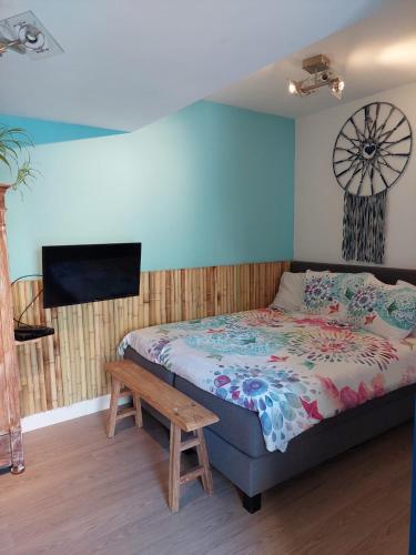 a bedroom with a bed and a flat screen tv at Studio Pipper in Zandvoort