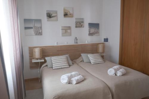 a bedroom with a bed with towels on it at ML Central Vila Apartment in Carvoeiro