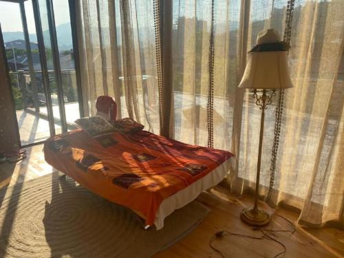 a bedroom with a bed and a lamp and a window at Batumi Wonderland in Batumi