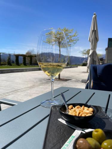 a glass of wine and a bowl of food on a table at BrixHome in Laveno-Mombello