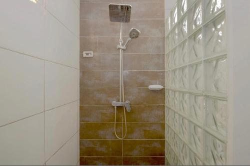 y baño con ducha con cabezal de ducha. en Appartement d'une chambre avec vue sur la ville piscine partagee et terrasse amenagee a Fort de France a 4 km de la plage en Fort-de-France