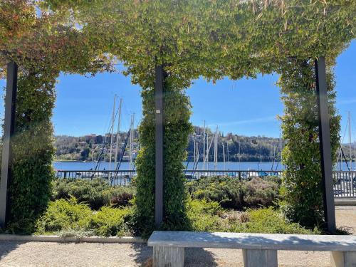a pergola with a bench in front of a marina at BrixHome in Laveno-Mombello