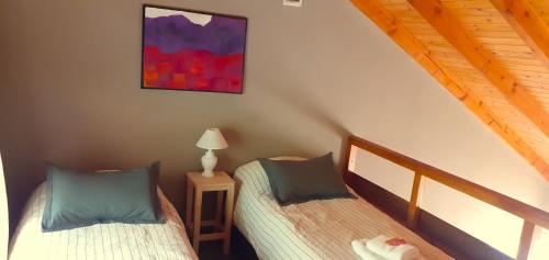2 łóżka pojedyncze w pokoju z: w obiekcie Malva w mieście El Bolsón