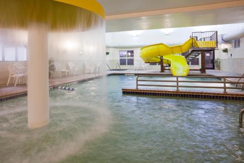 - une piscine avec toboggan dans une chambre d'hôtel dans l'établissement Expressway Suites Fargo, à Fargo