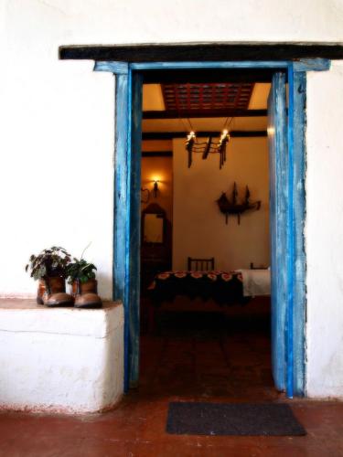 an open door into a room with a table at Hotel Boutique Casa de Hacienda Su Merced in Puembo