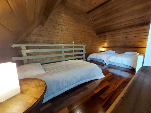 Un dormitorio con dos camas en una cabaña de madera. en Gîtes la Conterie, en Fatouville-Grestain