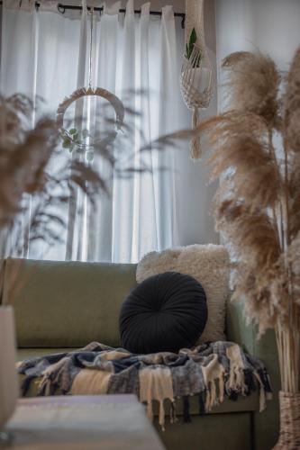 a pillow sitting on a couch in front of a window at Inconceptual apartment in Paradeísion