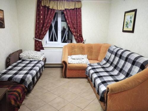 ein Wohnzimmer mit 2 Sofas und einem Fenster in der Unterkunft Parasolka in Luzk
