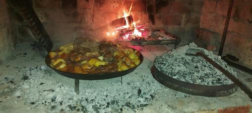 two pans of food cooking in a brick oven at Vikendica, Bazen, Šedrvan, Rafting na Uni, Quad in Bihać