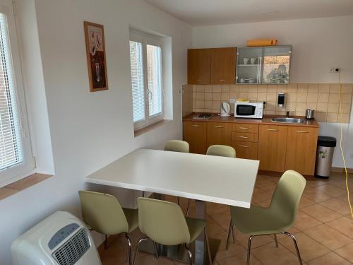 uma cozinha com uma mesa branca e cadeiras em Chata Omicron em Bítov