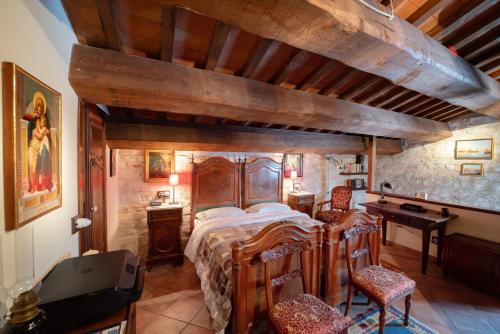 Degli Alessandri tower في Sassoferrato: غرفة نوم مع سرير خشبي كبير ومكتب