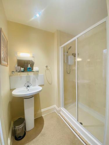 a bathroom with a sink and a shower at Coastal Waters (Hotel Barton) in Torquay