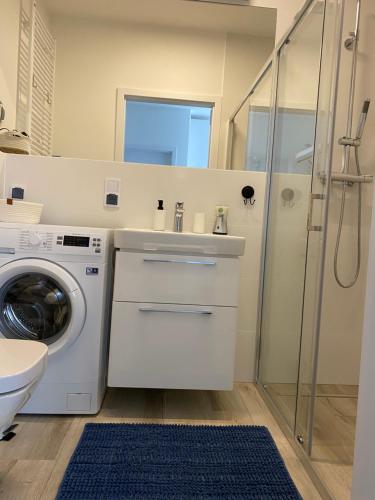łazienka z umywalką i pralką w obiekcie Apartament BLUE Rewal w Rewalu