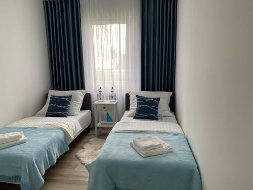 dwa łóżka w pokoju z niebieskim i białym w obiekcie Apartament BLUE Rewal w Rewalu