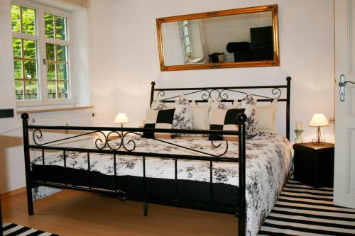 a bedroom with a black bed and a mirror at Ferienwohnung zur BlauEnte in Günzburg