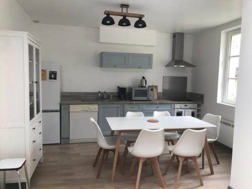 - une cuisine avec une table blanche et des chaises blanches dans l'établissement La Tranquillité proche Beauval et Châteaux de la Loire, à Loches