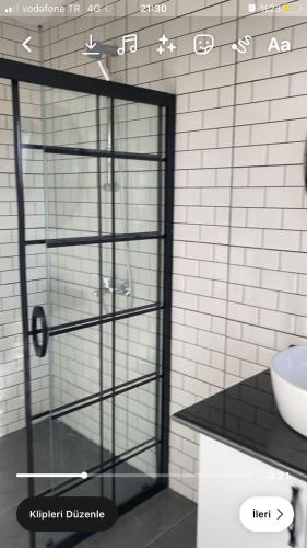 a glass shower door in a bathroom with a sink at Villa Eliz in Dalaman