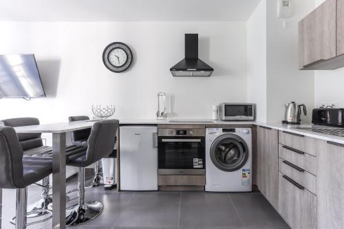une cuisine avec une machine à laver et une table dans l'établissement CANNES: Appartement Cosy à 2 pas de la Croisette, à Cannes