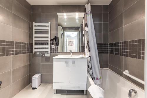 une salle de bain avec un lavabo, une baignoire et un miroir dans l'établissement CANNES: Appartement Cosy à 2 pas de la Croisette, à Cannes