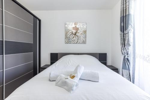 une chambre blanche avec un lit avec des serviettes dessus dans l'établissement CANNES: Appartement Cosy à 2 pas de la Croisette, à Cannes