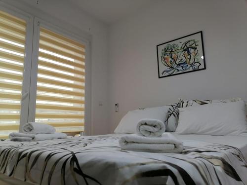 a bedroom with a bed with towels on it at Cosmopolit Apartments in Ohrid