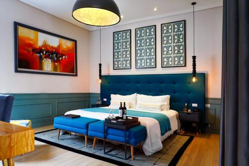 1 dormitorio con cama azul y banco azul en Illa Experience Hotel, en Quito