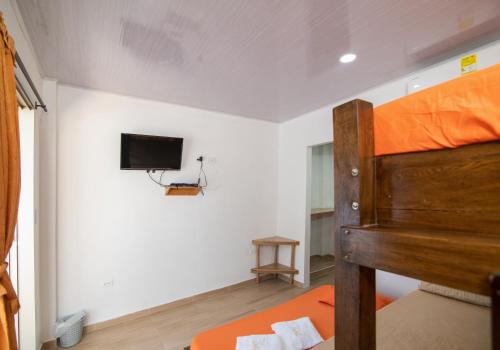 a bedroom with a bunk bed and a flat screen tv at Hotel Zabdi in Coveñas