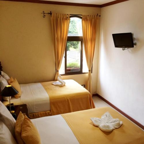 a hotel room with two beds and a window at Hotel Villa Florencia Zona Rosa in San Salvador