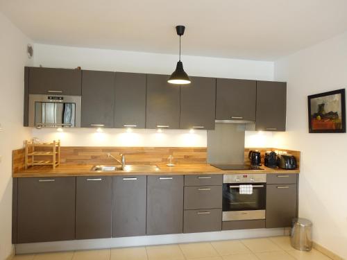 une cuisine avec des armoires grises et un évier dans l'établissement Lovely Appartement with Balcony 5min train station, à Cannes