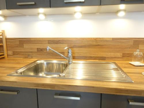 un évier en acier inoxydable dans une cuisine avec des comptoirs en bois dans l'établissement Lovely Appartement with Balcony 5min train station, à Cannes
